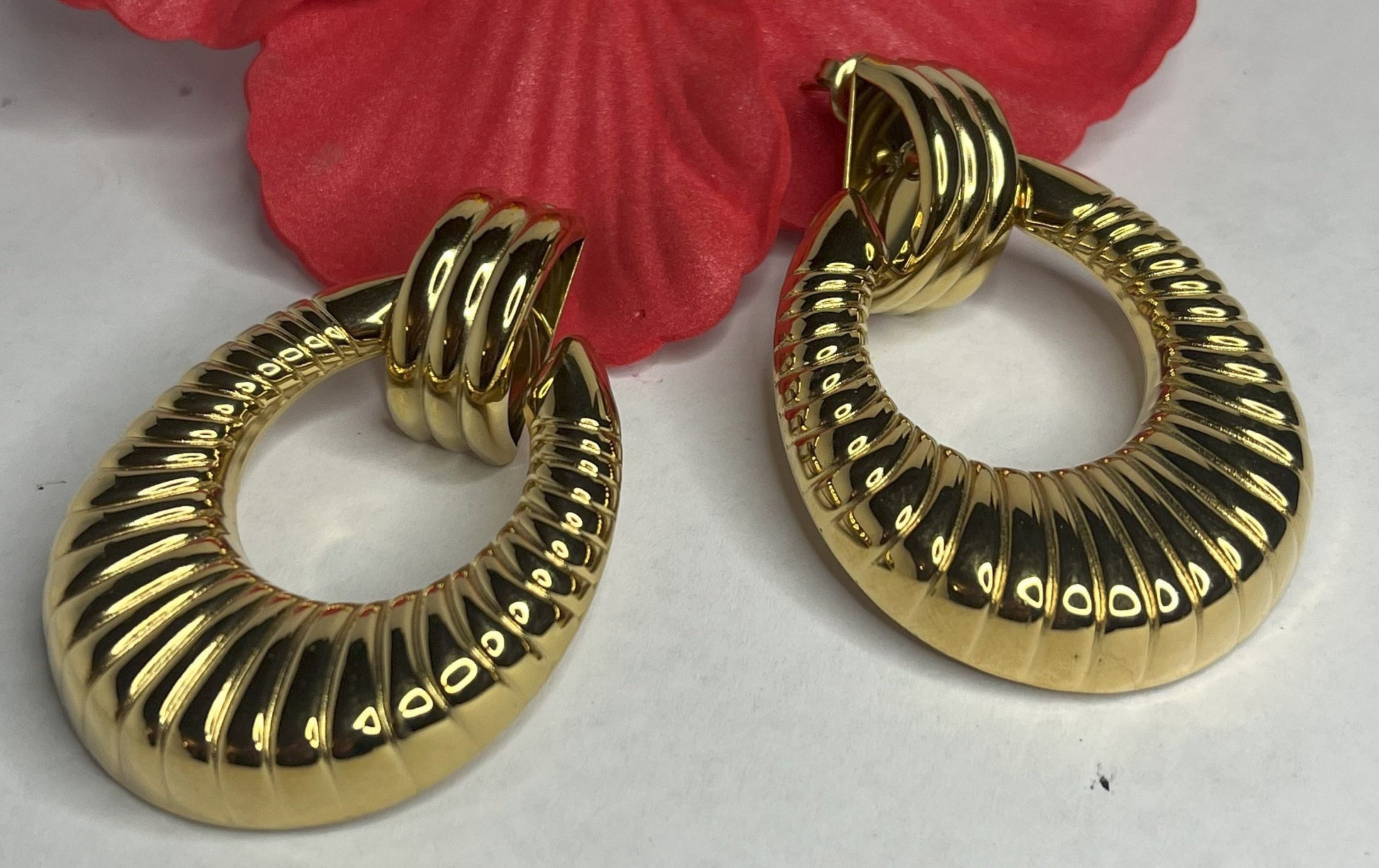 Orecchini Prestige Vintage Anni 80 placcati oro con design a cerchio scanalato, stile retrò elegante su sfondo bianco con fiore rosso decorativo