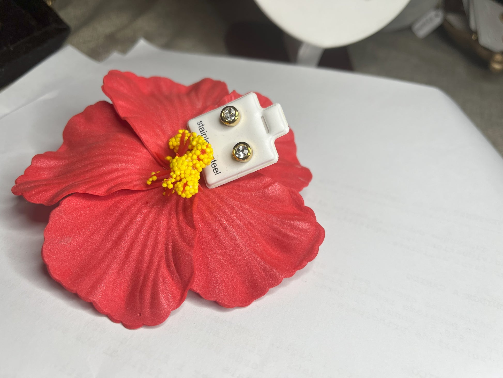 Coppia di orecchini punto luce in acciaio placcato su sfondo bianco con fiore rosso decorativo, design elegante a bottone con chiusura a farfallina