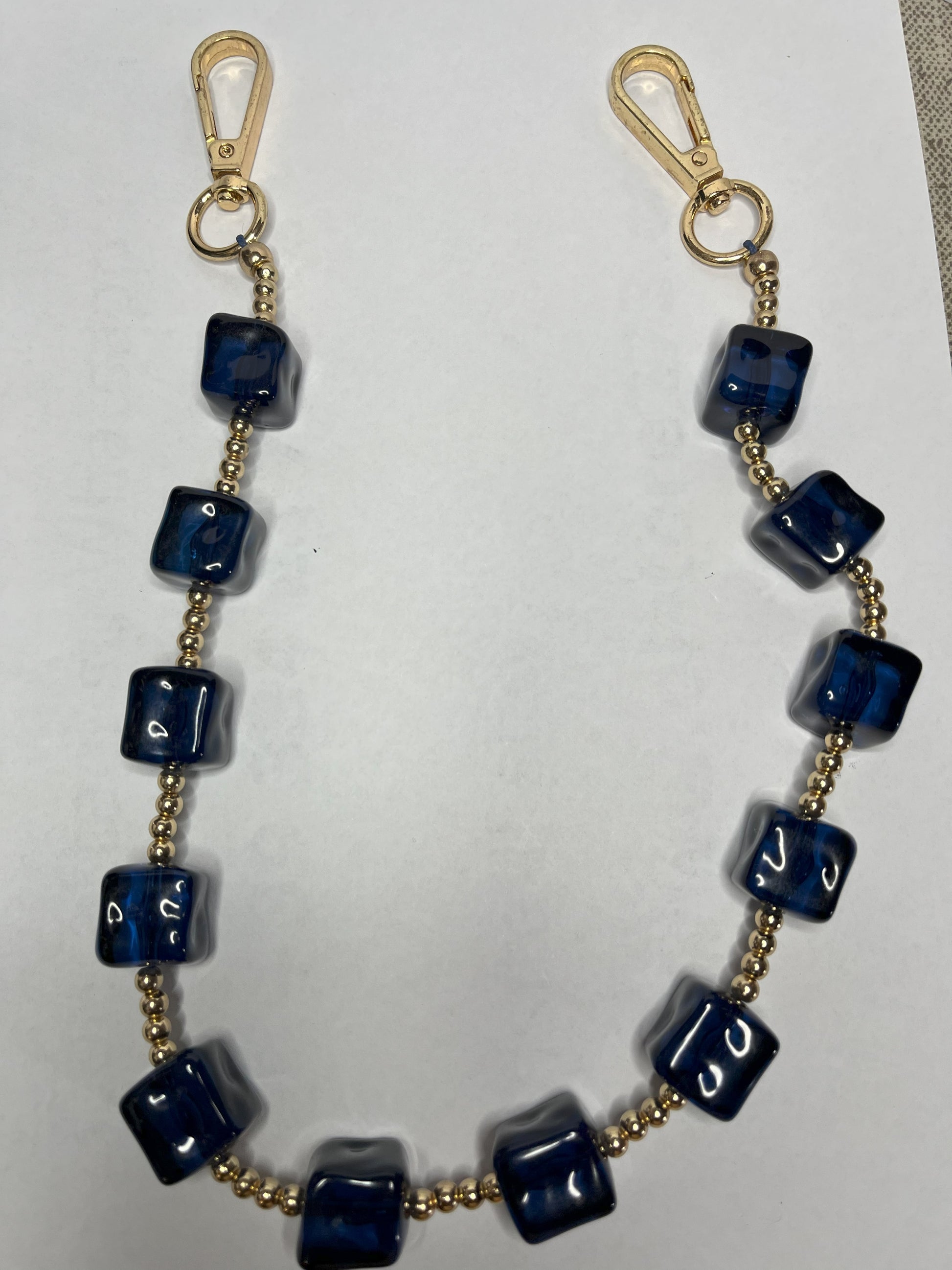 Accessorio multifunzione Trasforma Style con pietre quadrate in resina blu e dettagli dorati, utilizzabile come collana, tracolla per borsa o accessorio decorativo