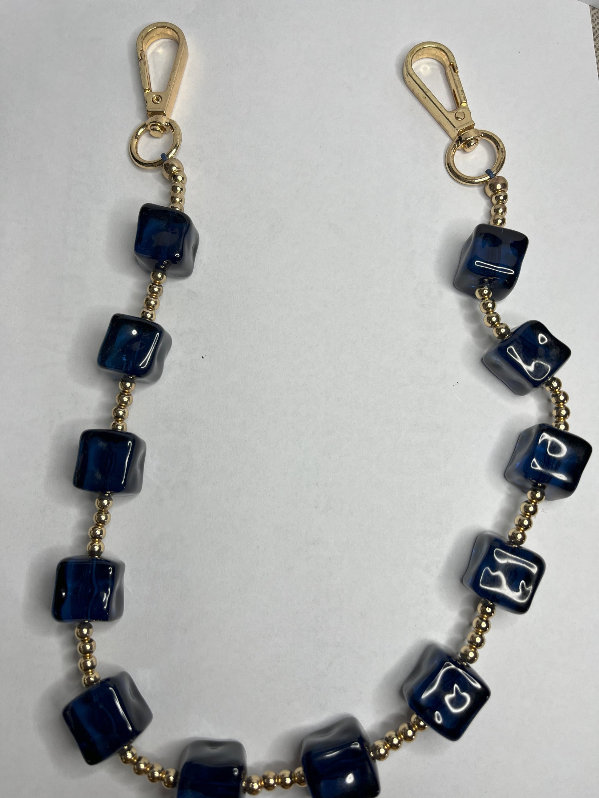 Accessorio multifunzione Trasforma Style con pietre quadrate in resina blu e dettagli dorati, utilizzabile come collana, tracolla per borsa o accessorio decorativo