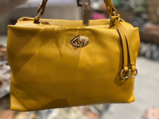 Borsa Sophie in pelle giallo senape con tracolla a catena dorata, chiusura centrale con logo metallico e design morbido e strutturato, perfetta per outfit casual e formali