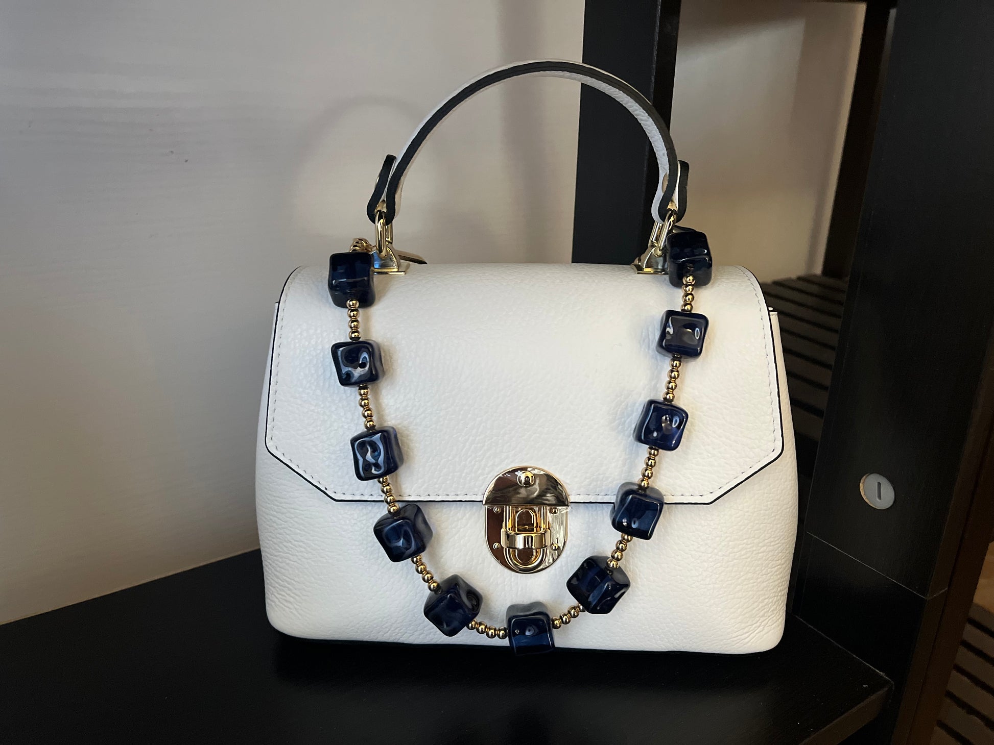 Borsa Zolla bianca in pelle con manico nero e decorazione a collana di perle quadrate blu navy e catena dorata, chiusura dorata e design compatto, perfetta per occasioni formali