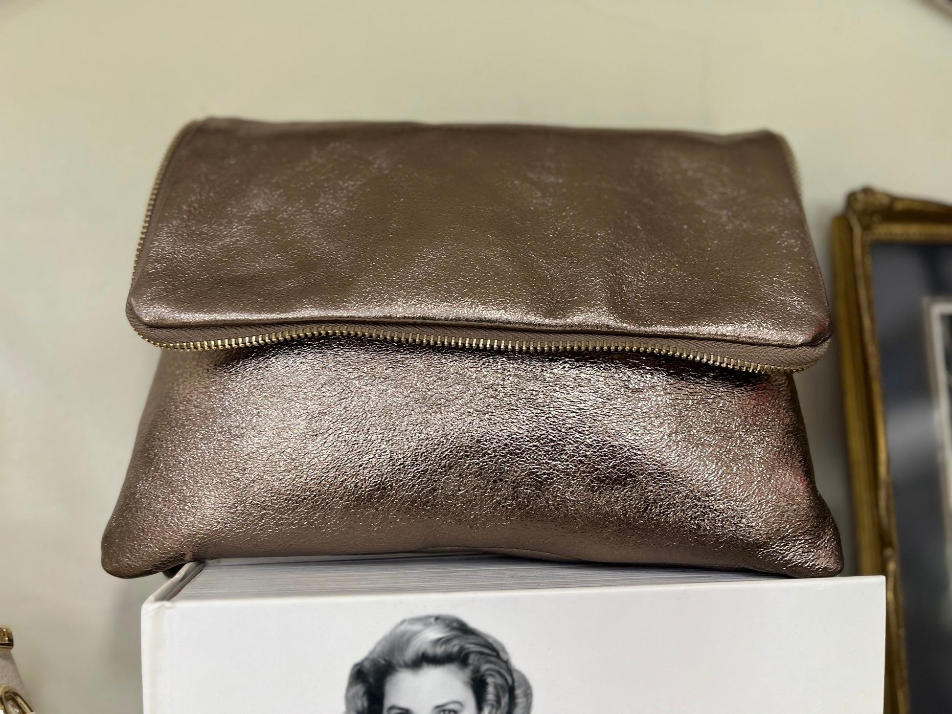 Borsa Cloe color bronzo effetto lucido con chiusura a zip, stile pochette pieghevole.