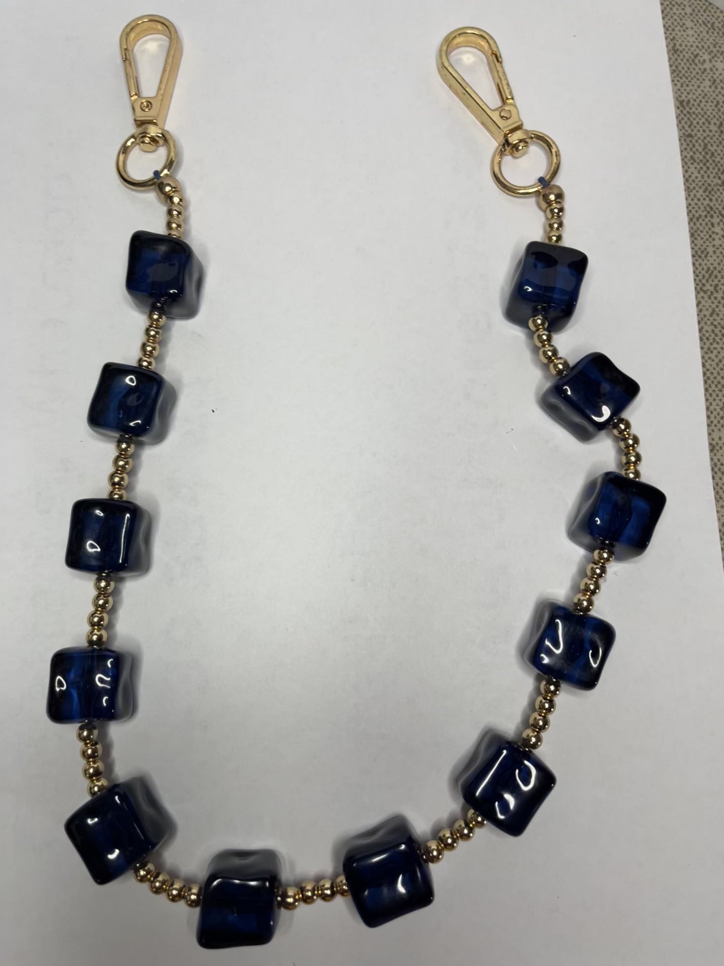 Accessorio multifunzione Trasforma Style con pietre quadrate in resina blu e dettagli dorati, utilizzabile come collana, tracolla per borsa o accessorio decorativo
