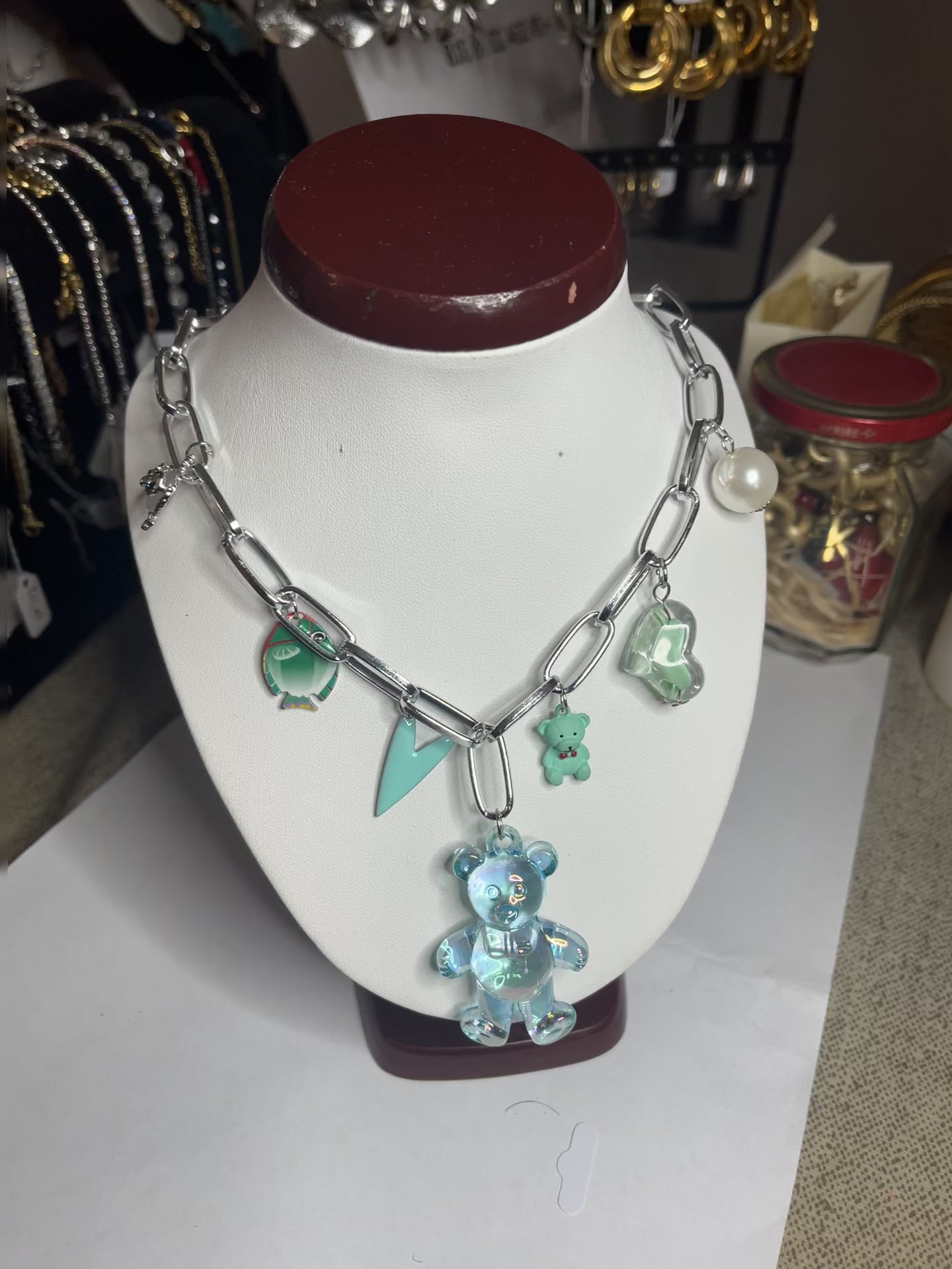 Collana chunky in alluminio trattato con orsetto turchese e pendenti verdi esposta su busto bianco