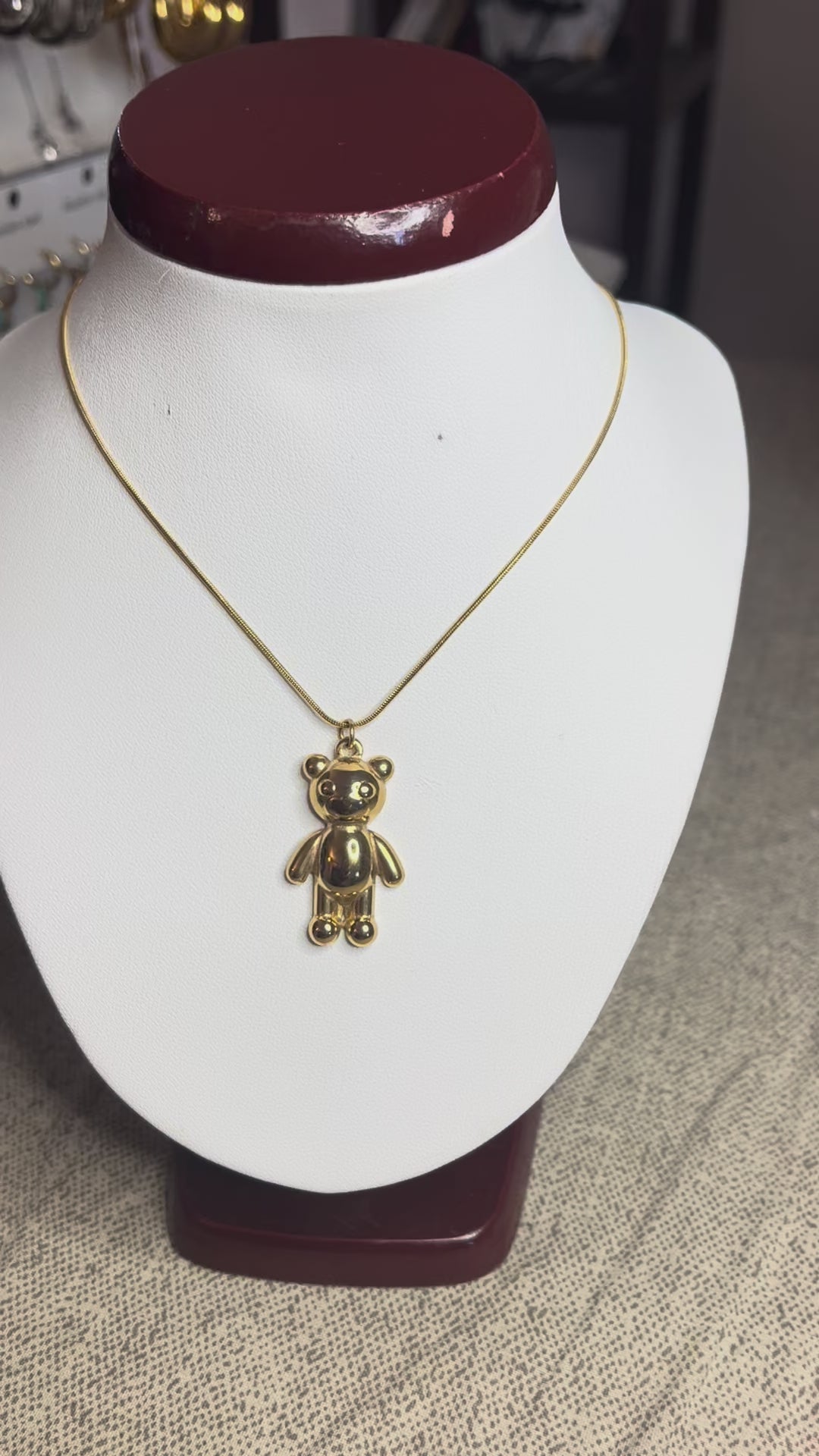 Collana Orsetto dei Sogni in acciaio premium con delicato ciondolo orsetto, variante placcato oro, esposta su busto espositore