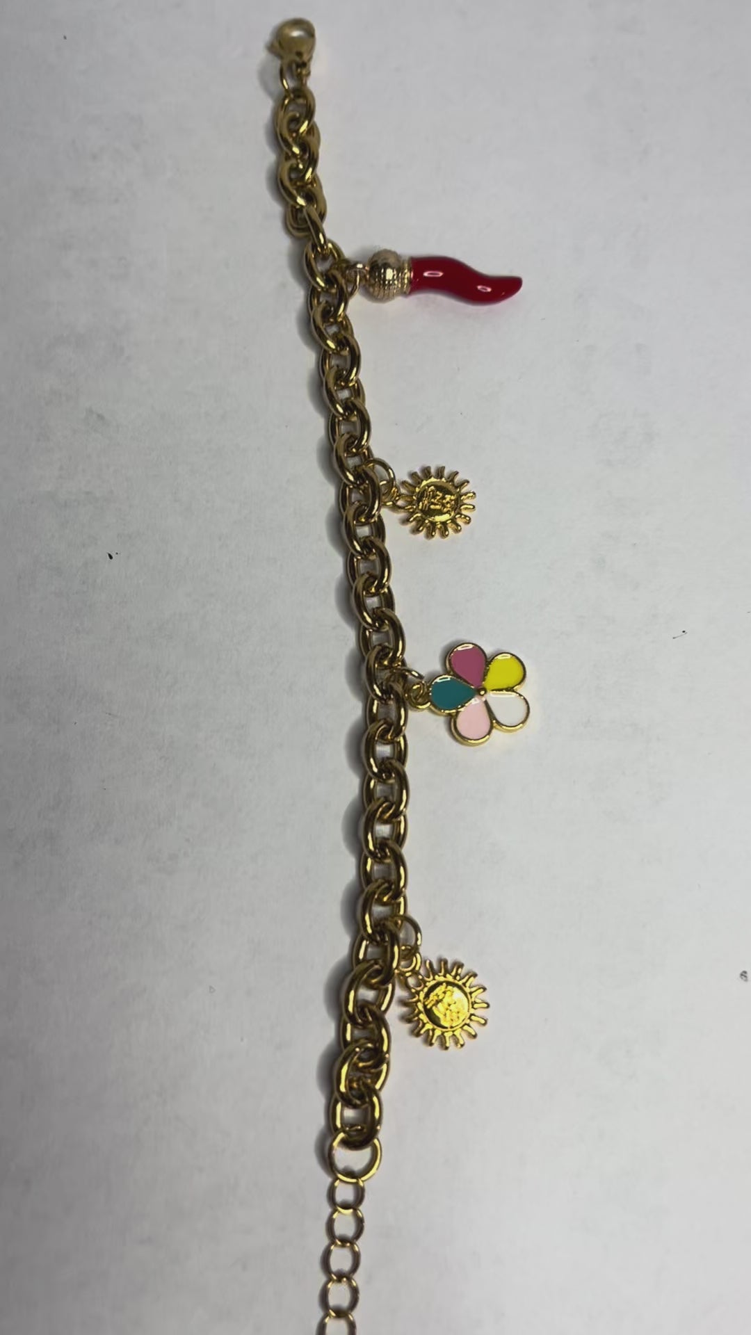 Braccialetto Amuleto Chic con catene dorate e argentate e charm portafortuna a forma di sole, fiore e cornetto rosso