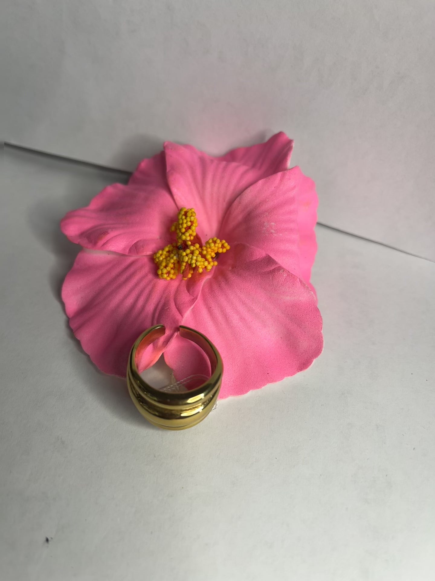 Anello Fascia Tripla placcato oro con tre fasce sovrapposte eleganti, design moderno e minimalista su fiore rosa