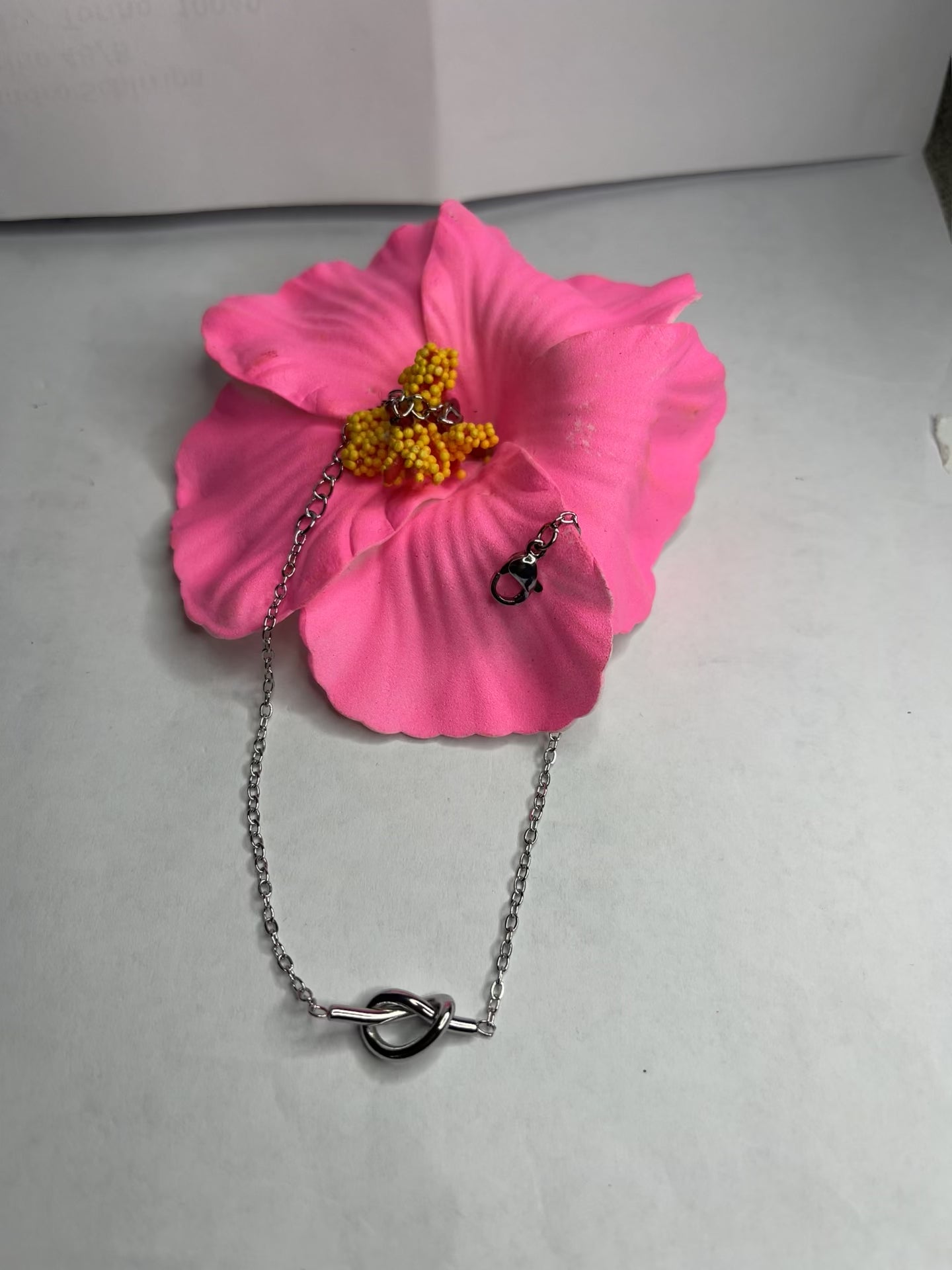 Braccialetto Giardino Magico in acciaio inox argentato con charms floreali, cuori rossi e perline colorate su sfondo grigio