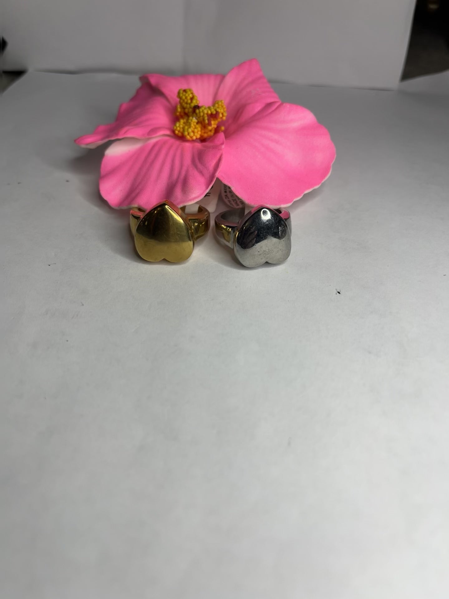 Anello Cuore Eterno con design bombato arrotondato, disponibile in versione placcata oro e argento su fiore rosa decorativo