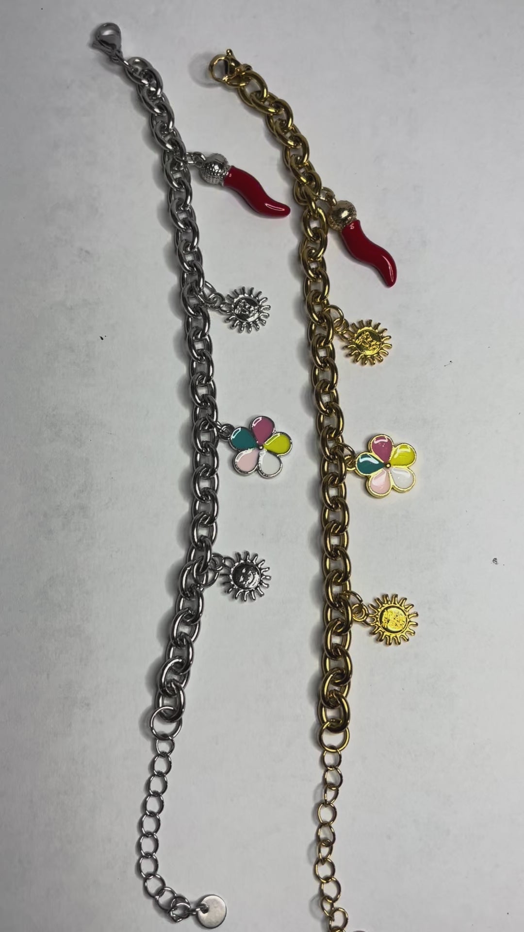 Braccialetto Amuleto Chic con catene dorate e argentate e charm portafortuna a forma di sole, fiore e cornetto rosso