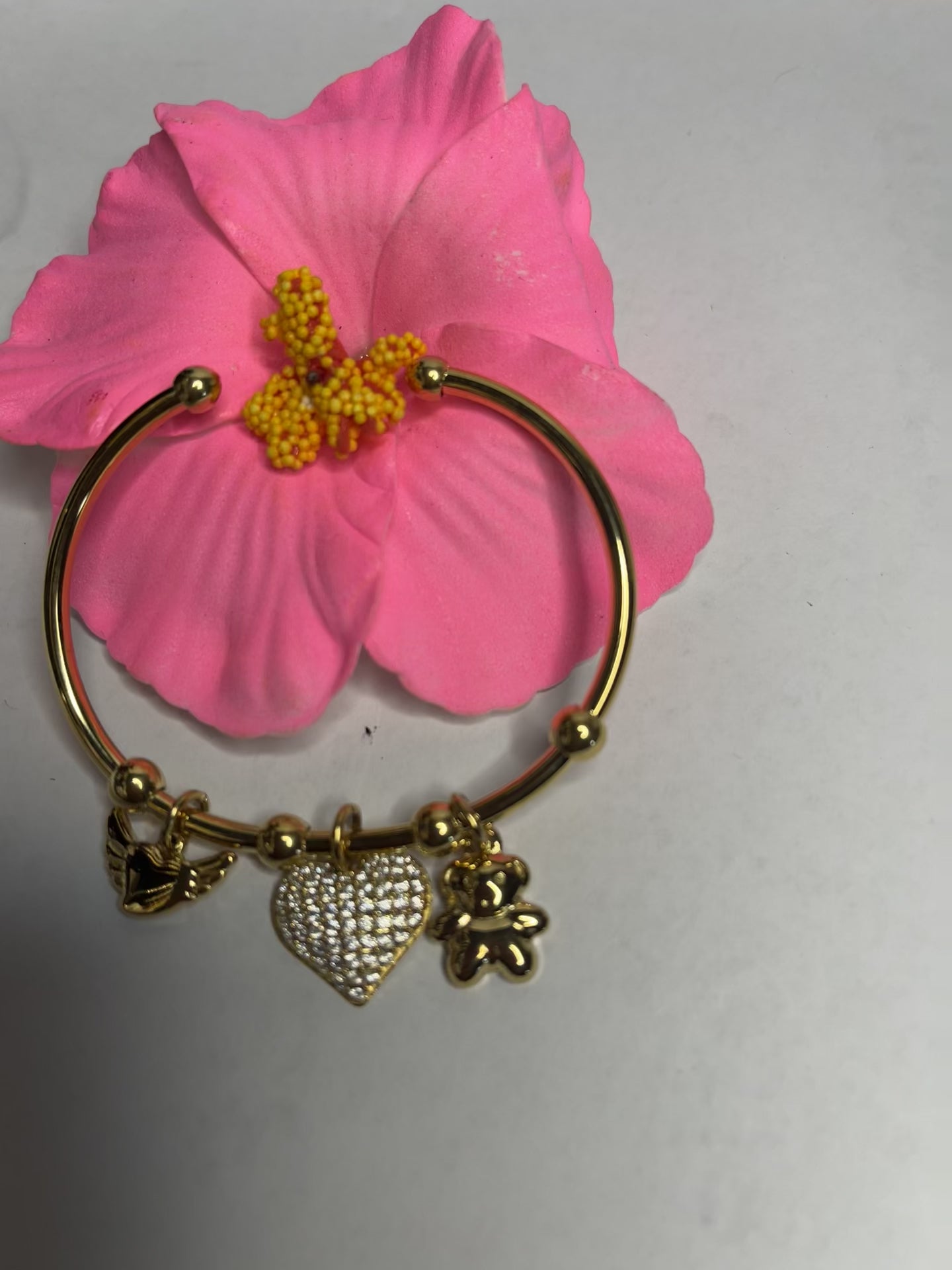 "Braccialetto Trio Charms dorato con cuore cristalli, fiore decorativo e charm elegante"