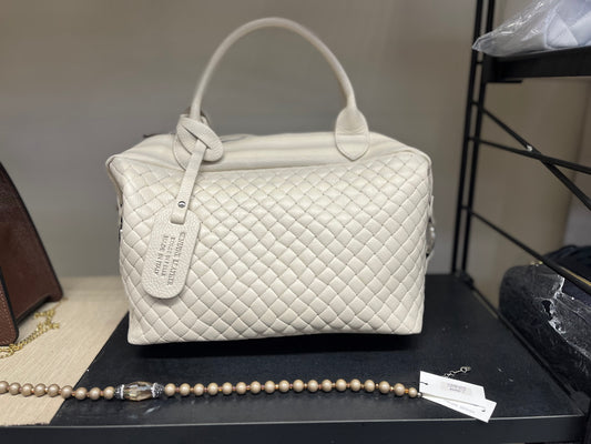 Victoria - Borsa trapuntata elegante in pelle beige con manici e tag identificativo, design a rombi e finitura lucida, esposta con bracciale di perle