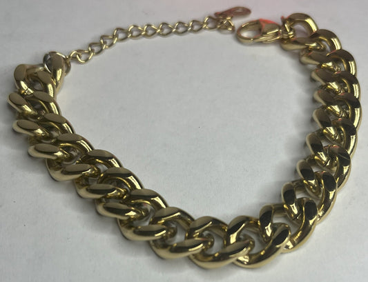 Bracciale Bold Chain placcato oro con maglie chunky grandi su sfondo grigio con petali rosa
