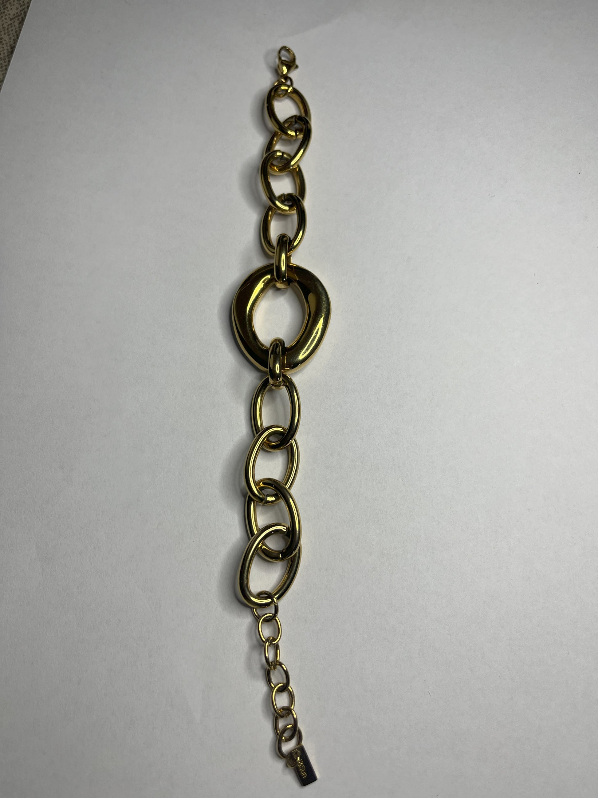 Bracciale Gold Evolution in acciaio 316L placcato oro con maglie graduate e anello centrale statement, su sfondo grigio neutro