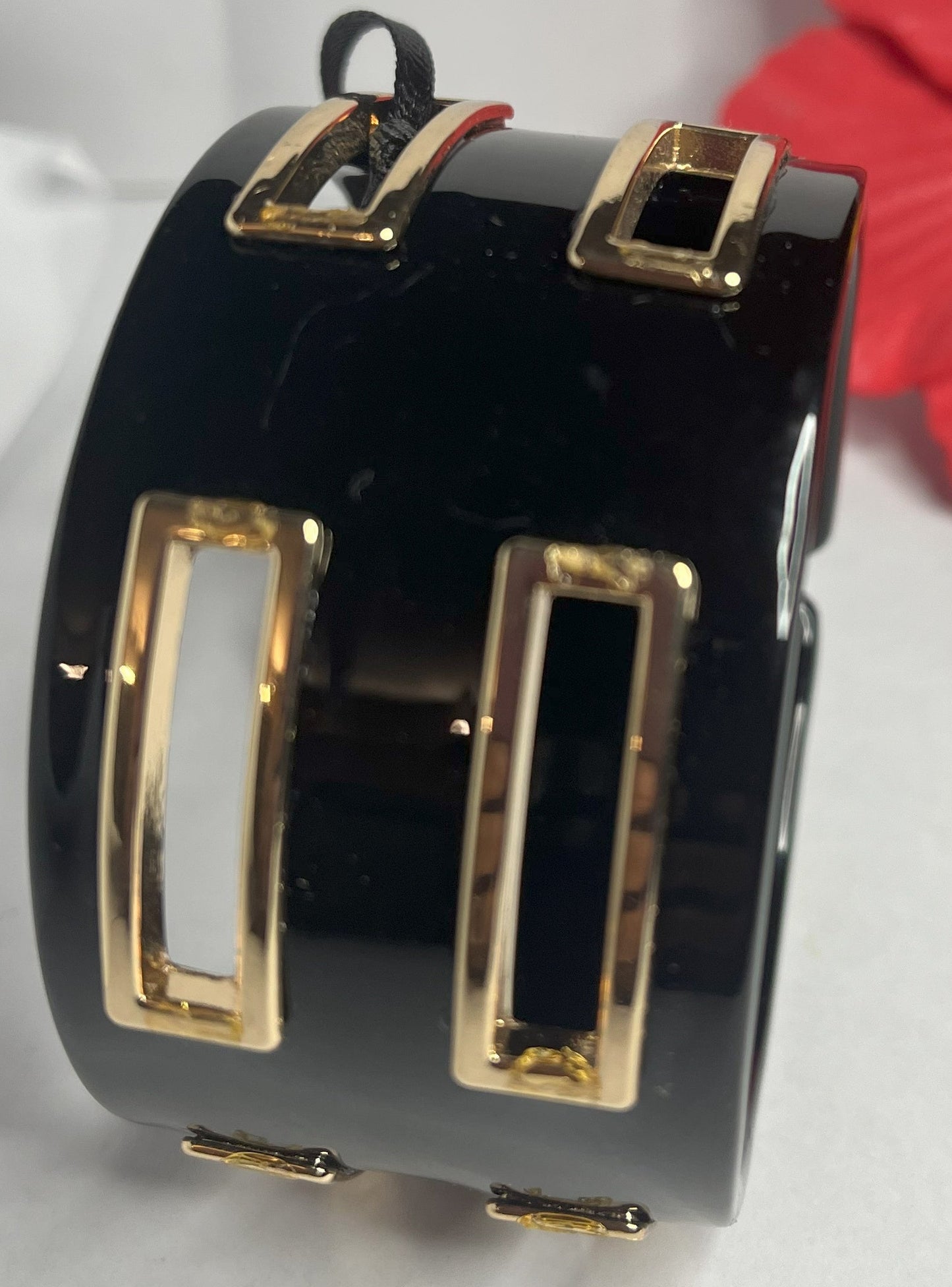 Bracciale rigido Golden Fusion nero con inserti geometrici placcati oro, design moderno ed elegante su sfondo bianco
