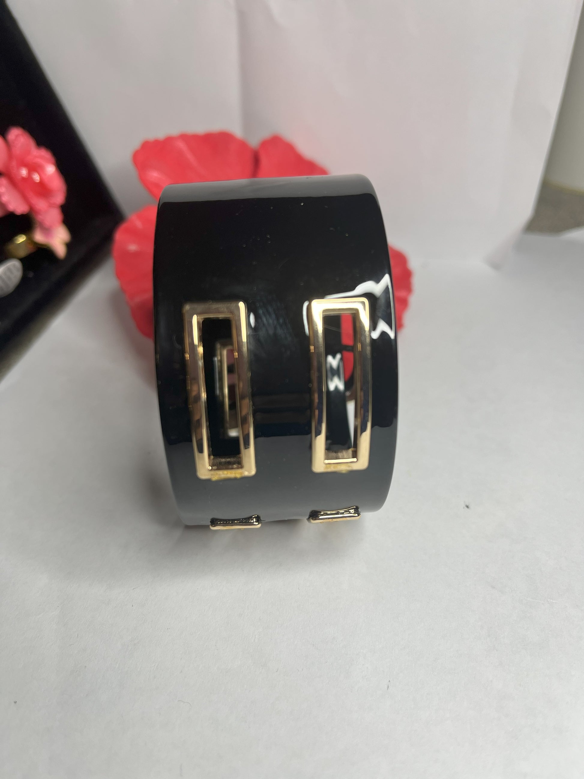Bracciale rigido Golden Fusion nero con inserti geometrici placcati oro, design moderno ed elegante su sfondo bianco