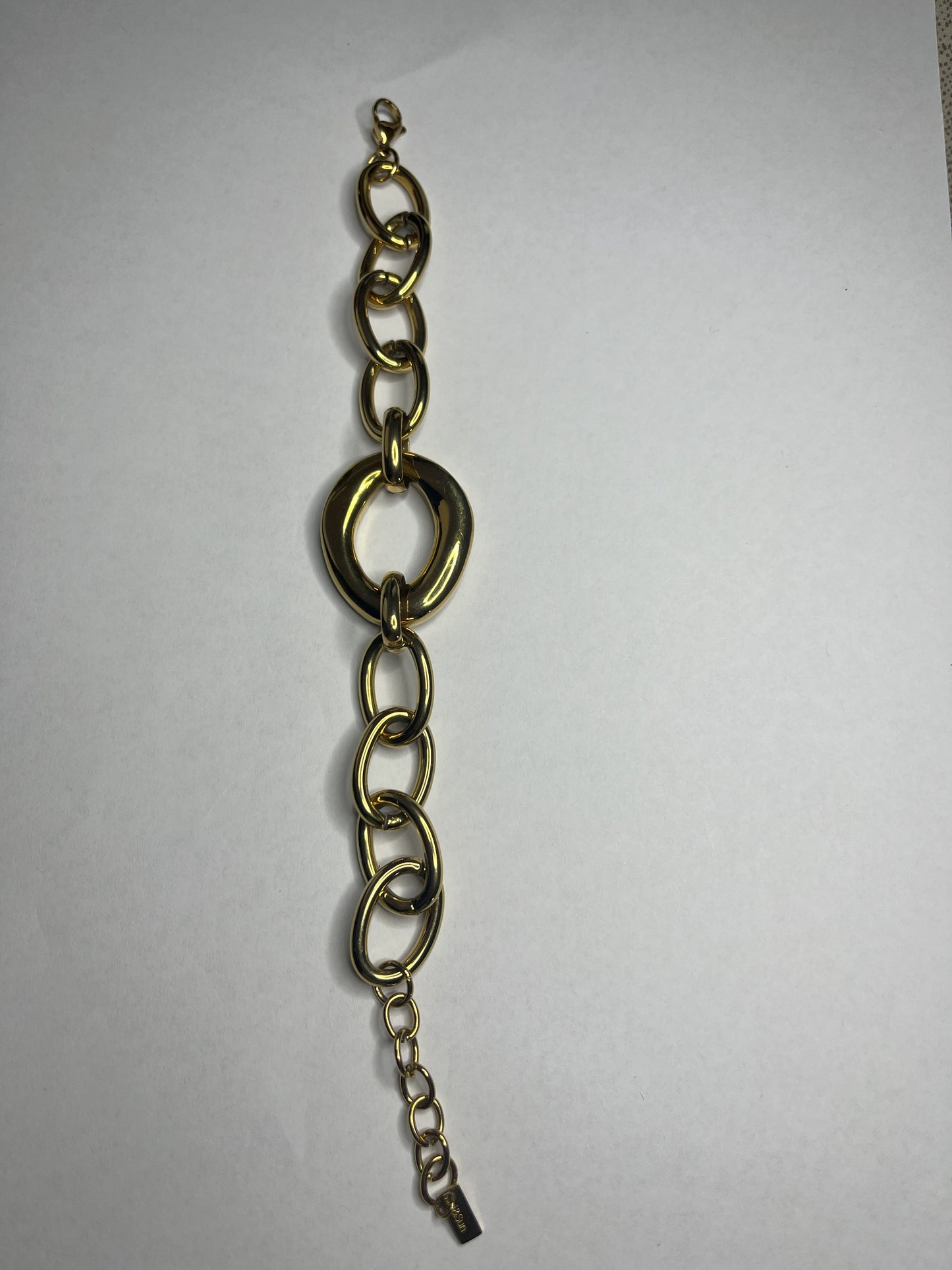 Bracciale Gold Evolution in acciaio 316L placcato oro con maglie graduate e anello centrale statement, su sfondo grigio neutro
