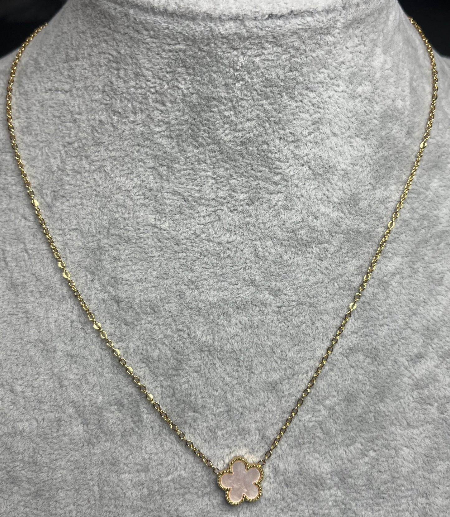 Collana ciondolo stella rosa e catena dorata su busto espositore