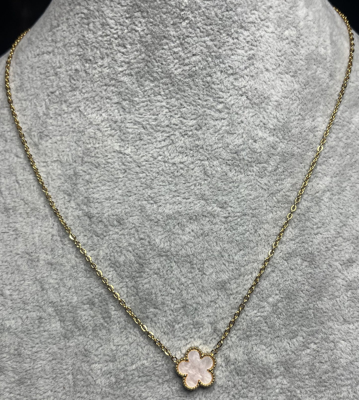 Collana ciondolo stella rosa e catena dorata su busto espositore