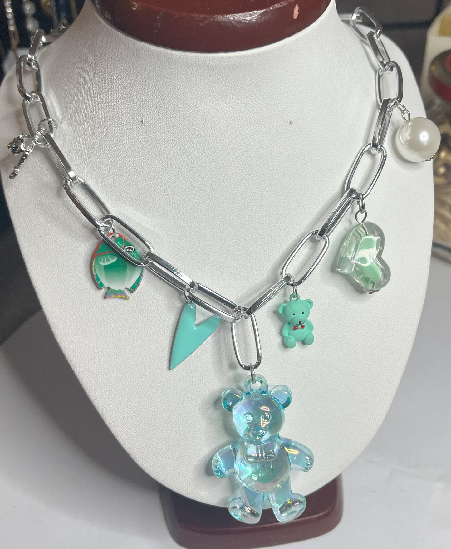 Collana chunky in alluminio trattato con orsetto turchese e pendenti verdi esposta su busto bianco