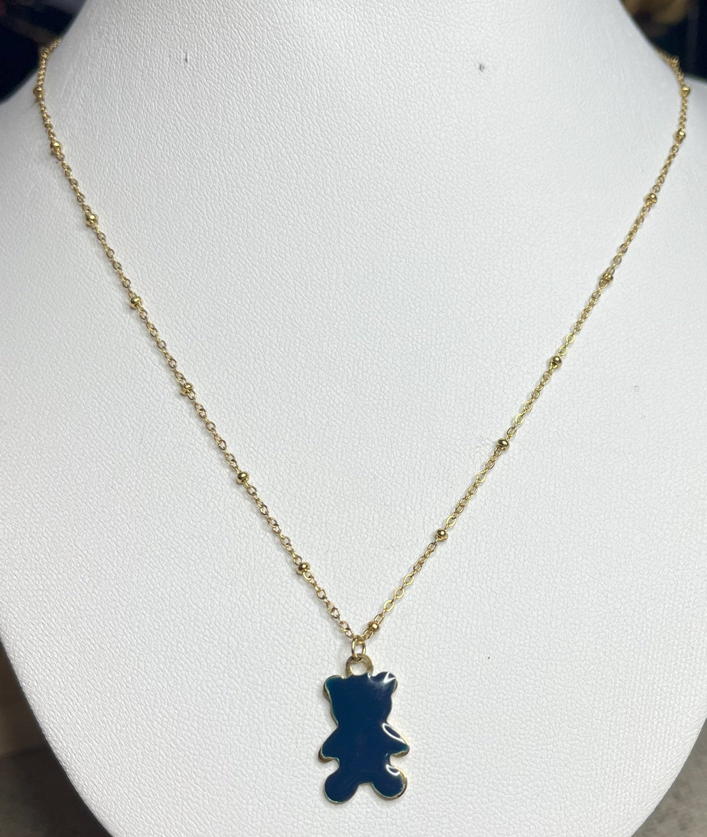 Collana Teddy con ciondolo orsetto blu in smalto e catena dorata, esposta su busto bianco