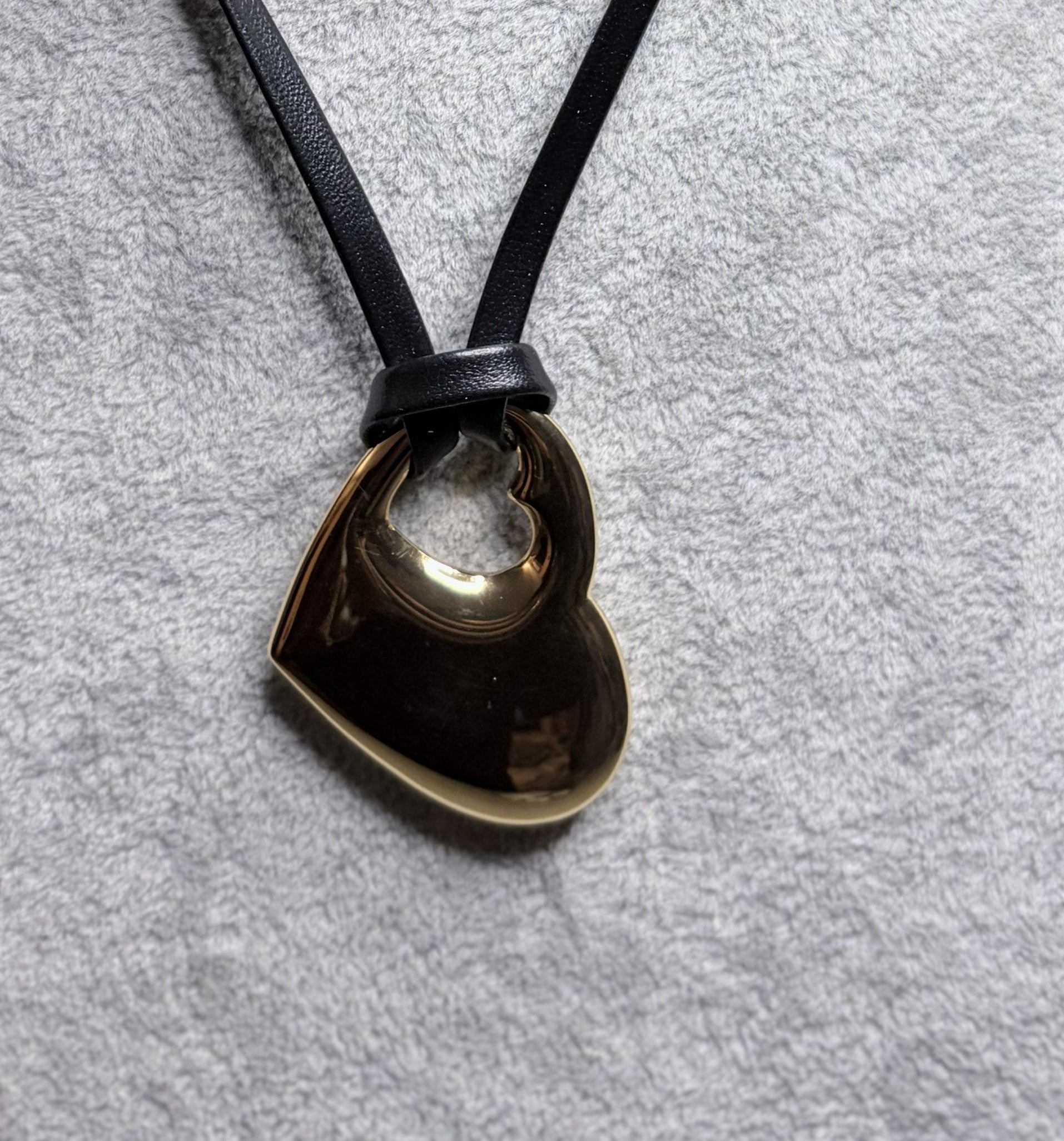 Collana cordino nero cuore forato oro — dettaglio ciondolo e nodo scorrevole