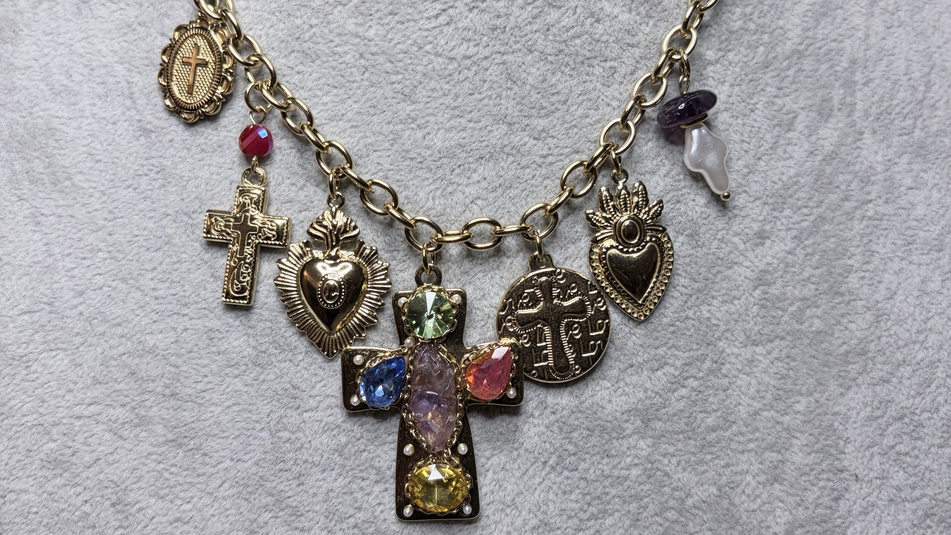 Collana charm sacro vintage placcata oro su busto espositore - primo piano