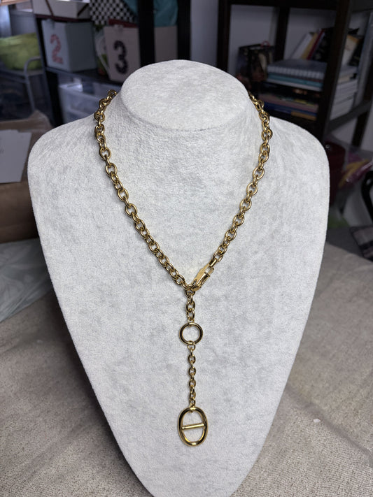 Collana lariat dorata con ciondolo ovale su busto bianco — vista frontale completa