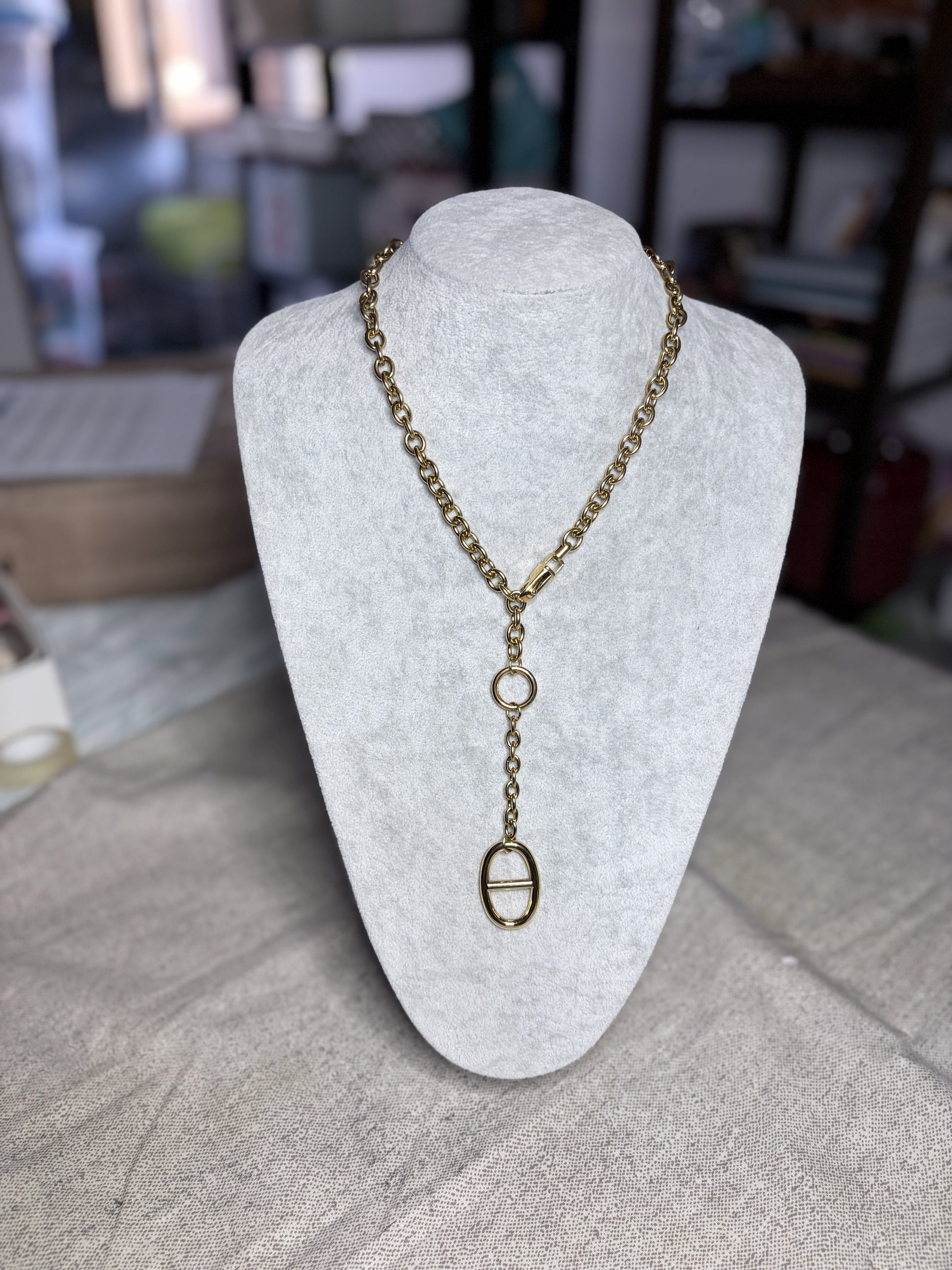 Collana lariat oro su busto bianco — vista laterale con pendente asimmetrico