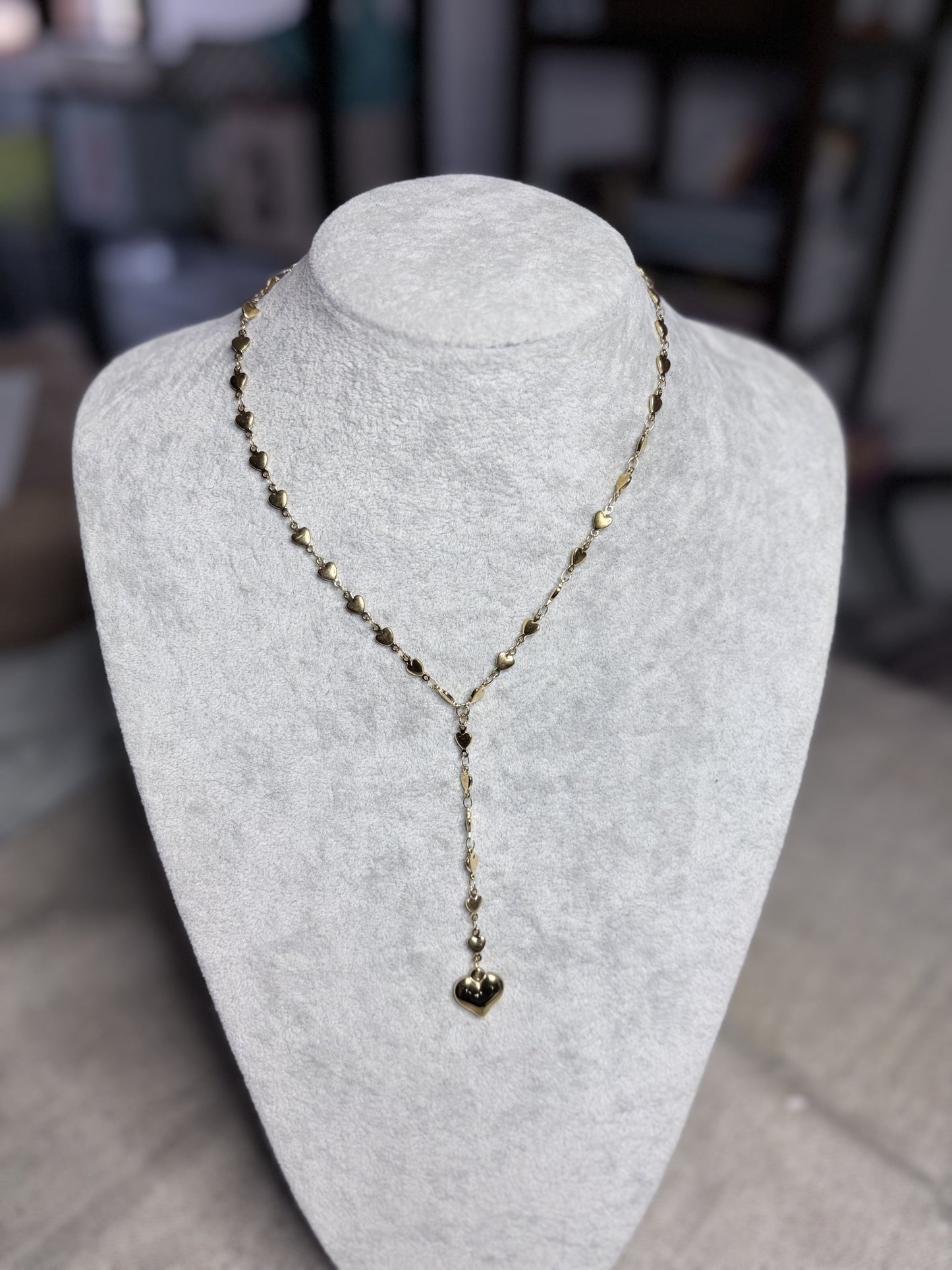 Collana lariat dorata cuoricini — vista completa su busto bianco