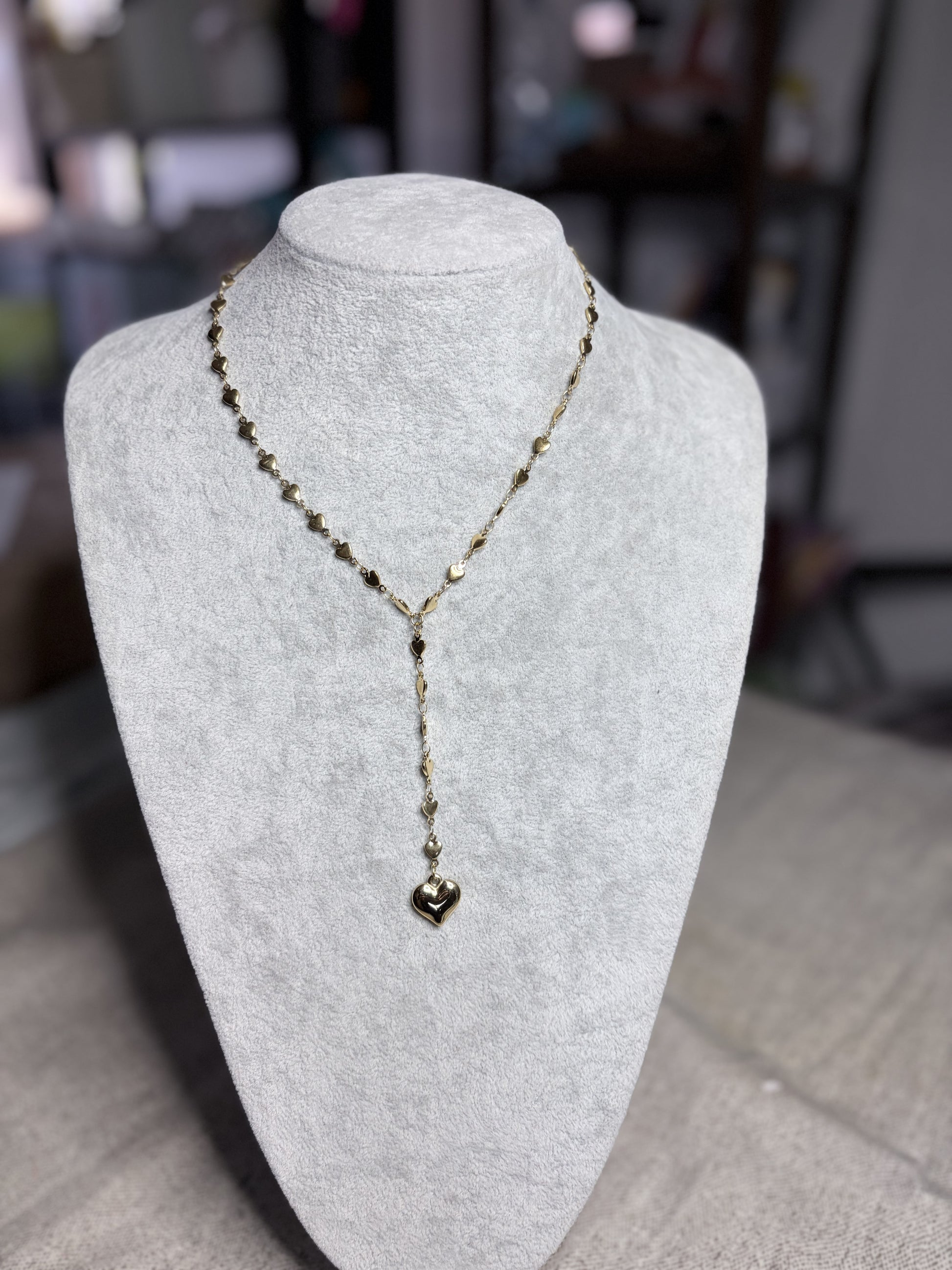 Collana lariat dorata cuoricini — vista completa su busto bianco