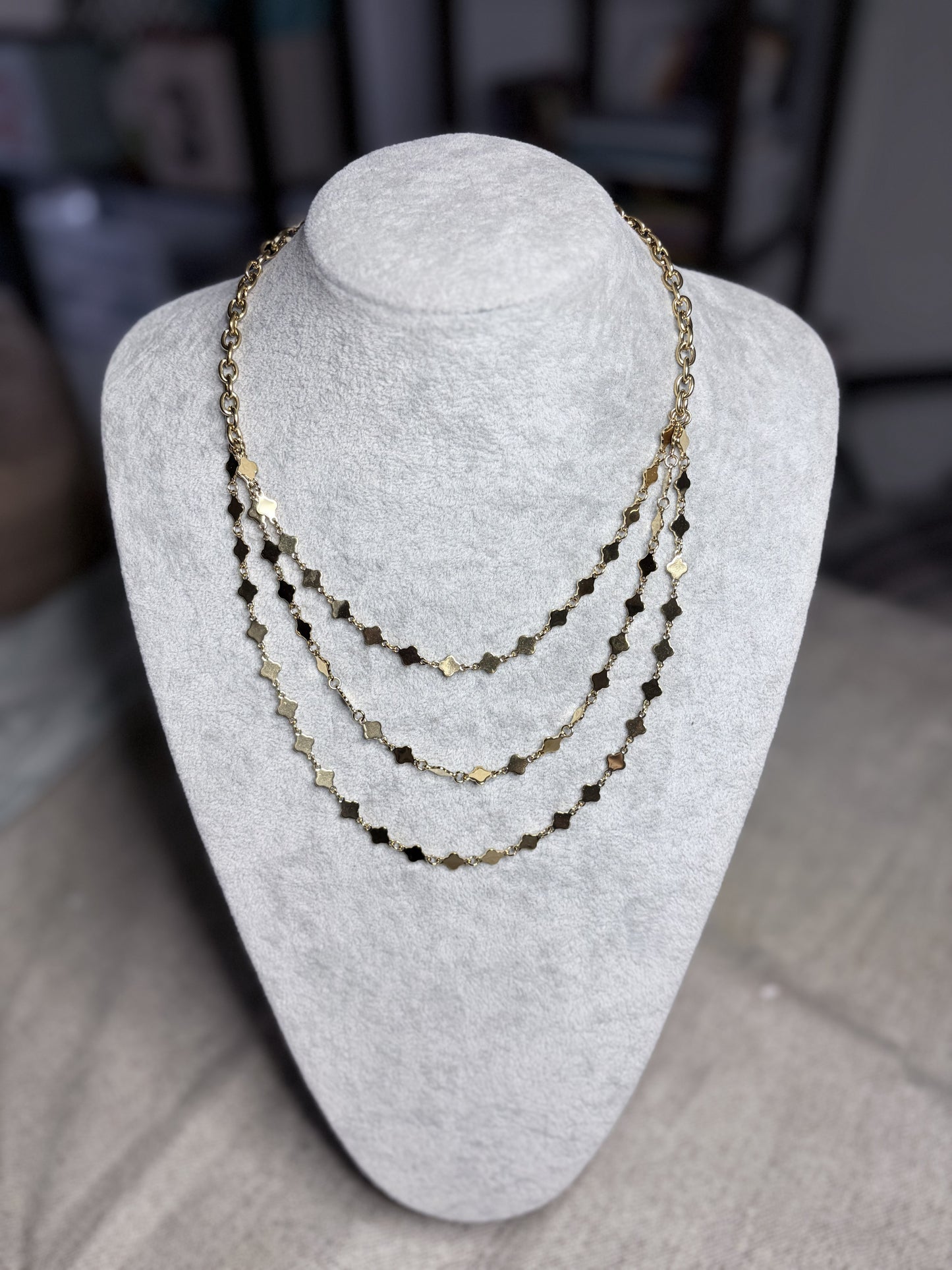 Collana multifilo dorata con stelline su busto bianco