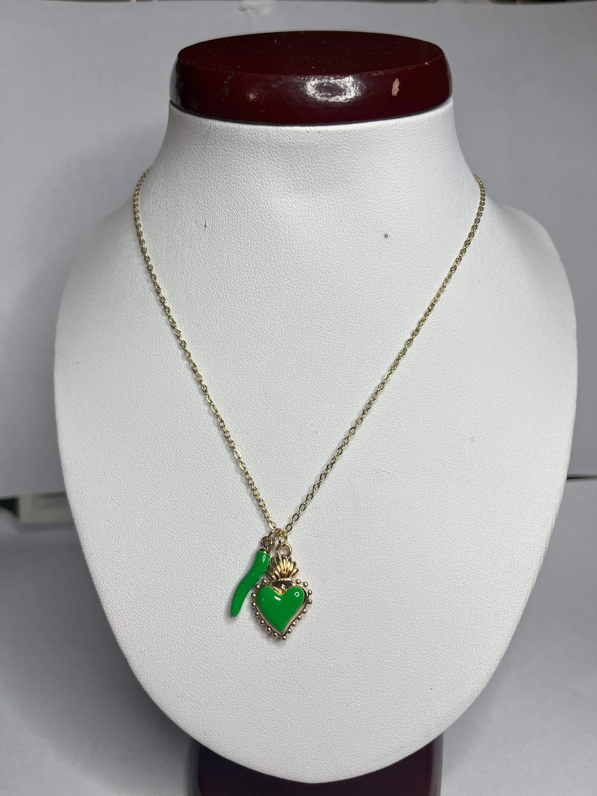 Collana Love Charm con catena dorata e doppio pendente a forma di cuore e cornetto portafortuna, disponibile in vari colori