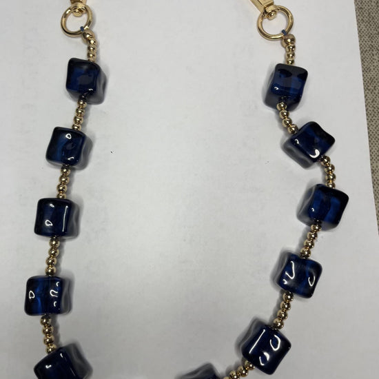 Accessorio multifunzione Trasforma Style con pietre quadrate in resina blu e dettagli dorati, utilizzabile come collana, tracolla per borsa o accessorio decorativo