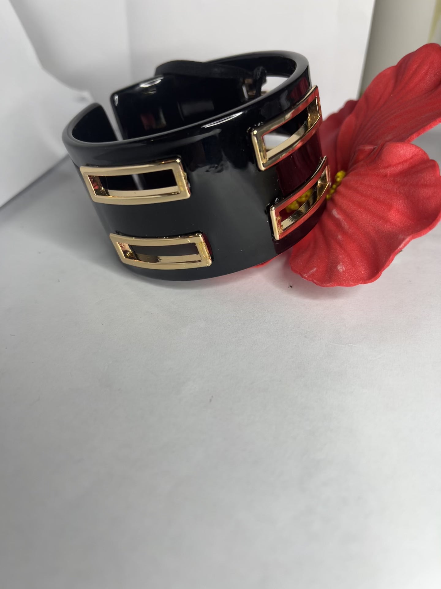 Bracciale rigido Golden Fusion nero con inserti geometrici placcati oro, design moderno ed elegante su sfondo bianco