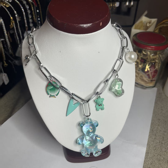 Collana chunky in alluminio trattato con orsetto turchese e pendenti verdi esposta su busto bianco