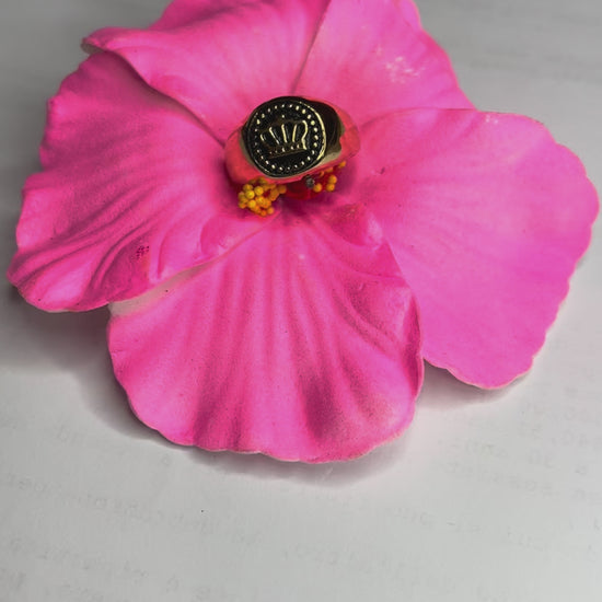 Anello Mignolo Regina in acciaio premium con design regale inciso, variante placcato oro, fotografato su superficie bianca con fiore rosa 