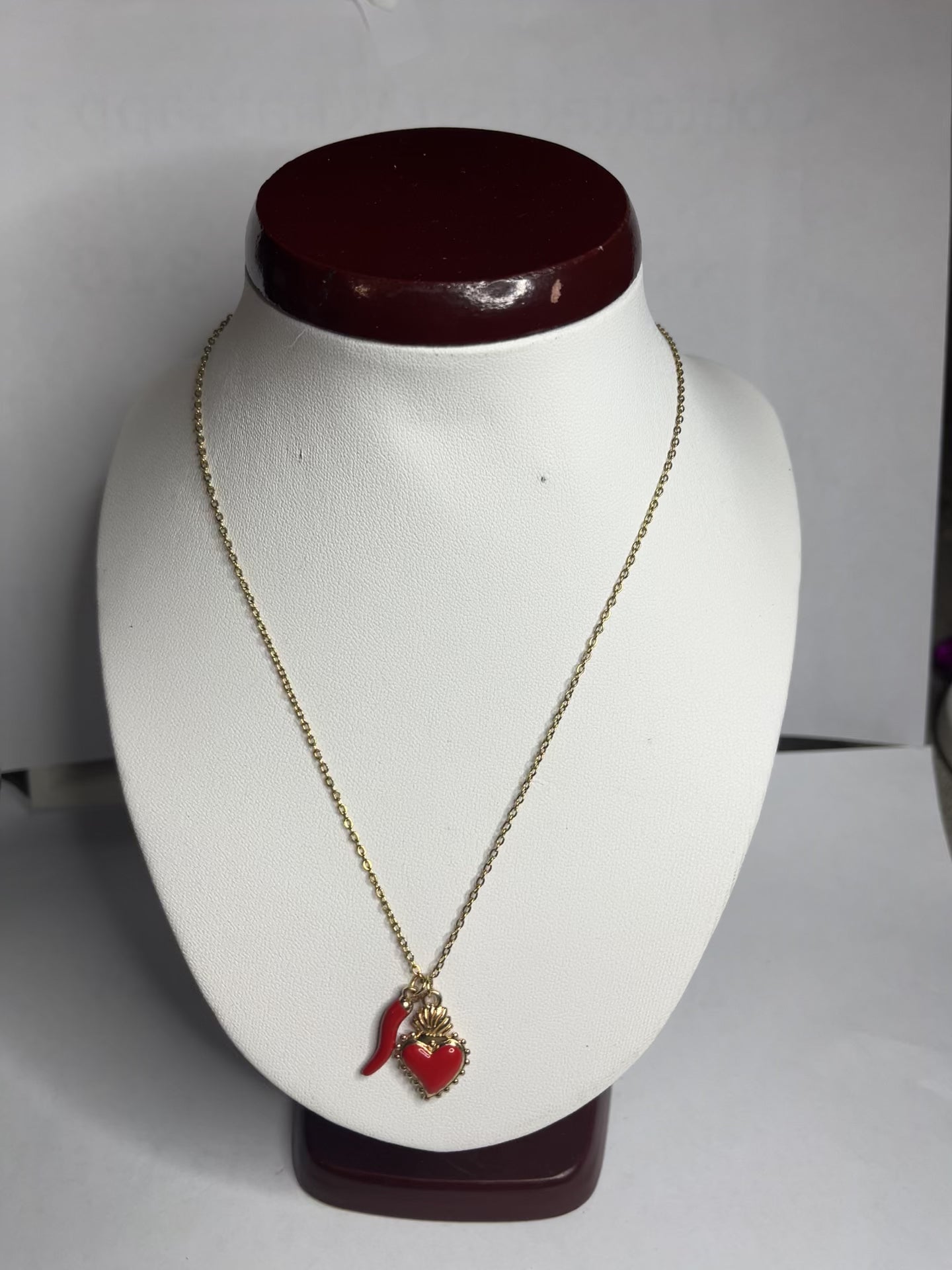 Collana Love Charm con catena dorata e doppio pendente a forma di cuore e cornetto portafortuna, disponibile in vari colori