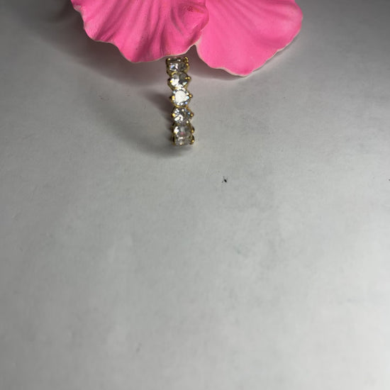 Anello Elegance Wide con fascia larga placcata oro, design minimalista elegante esposto su fiore rosa decorativo