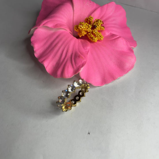  Anello Elegance Wide con fascia larga placcata oro, design minimalista elegante esposto su fiore rosa decorativo