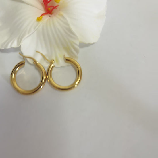 Orecchini creoli dorati placcati oro a forma di cerchio con finitura lucida su sfondo bianco