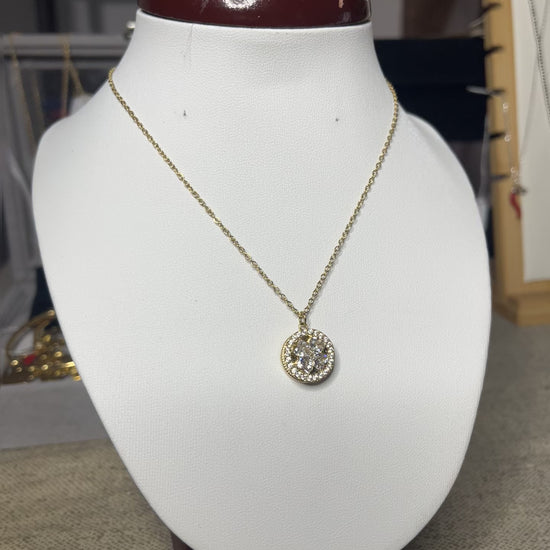 Collana Wish con elegante ciondolo quadrifoglio dorato e dettagli scintillanti, esposta su busto porta gioielli bianco