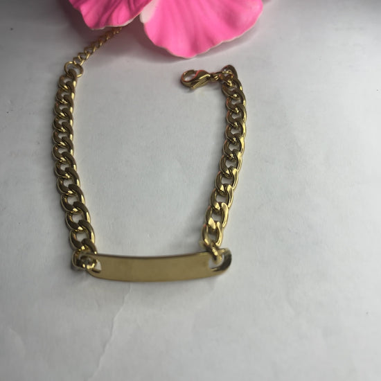 Bracciale Golden Thread sottile placcato oro con maglia fine delicata su sfondo grigio con petali rosa
