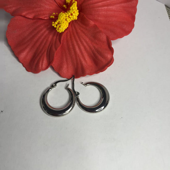 Set di orecchini creoli placcati, due paia in oro e argento, disposti su sfondo neutro con fiore rosso decorativo