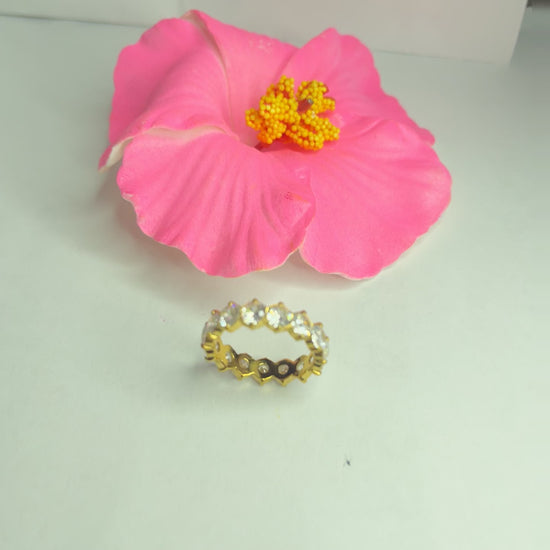  Anello Elegance Wide con fascia larga placcata oro, design minimalista elegante esposto su fiore rosa decorativo