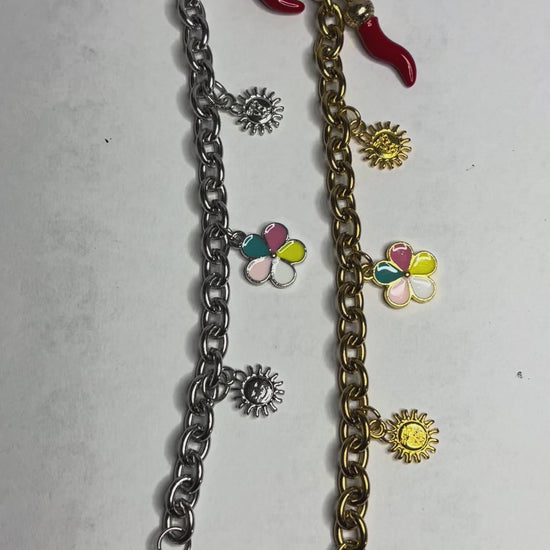 Braccialetto Amuleto Chic con catene dorate e argentate e charm portafortuna a forma di sole, fiore e cornetto rosso