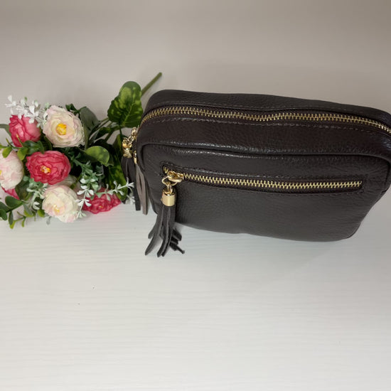 Borsa Mogano Premium in vera pelle testa di moro Made in Italy con doppia cerniera dorata, nappa decorativa e tracolla intrecciata regolabile, fotografata su superficie bianca 