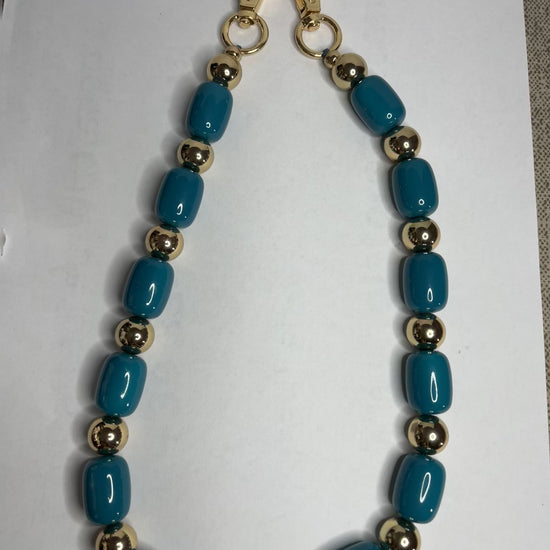 Accessorio multifunzione Oval Multistyle con perle ovali sintetiche fucsia e turchese e dettagli dorati, utilizzabile come collana, tracolla per borsa o accessorio decorativo